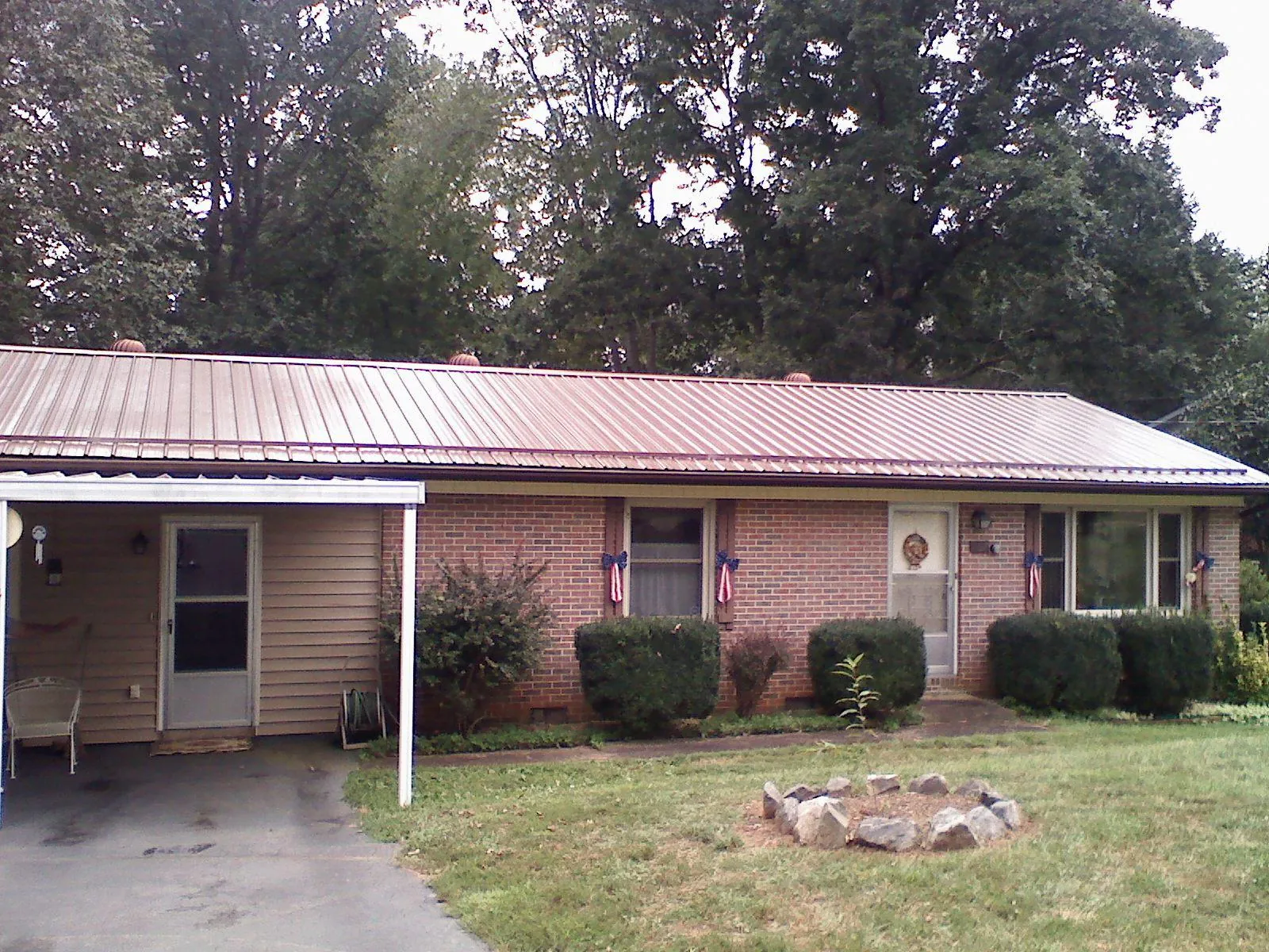 Bronze metal roof and carport on a brick ranch home — Roof Repair work by our crew in Bridgeport